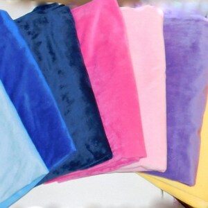 May include: A stack of eight fabric swatches in various colors, including light blue, dark blue, navy blue, pink, light pink, purple, yellow, and brown.