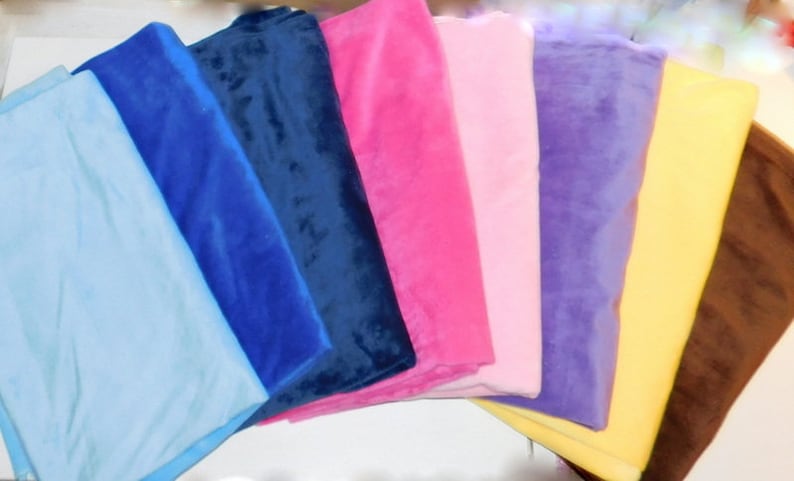 May include: A stack of eight fabric swatches in various colors, including light blue, dark blue, navy blue, pink, light pink, purple, yellow, and brown.