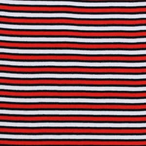 May include: Red and white striped fabric with thin black stripes. The fabric is measured with a ruler in inches.