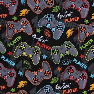 May include: Black fabric with a repeating pattern of colorful video game controllers and the text "the best player".
