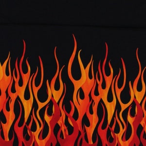 May include: A black fabric with a repeating pattern of orange and red flames. The flames are stylized and have a jagged edge.