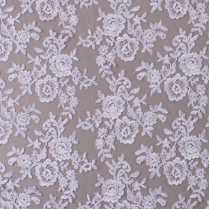 May include: White floral lace fabric with a delicate pattern of small flowers and leaves. The fabric is soft and sheer, and it would be perfect for a variety of projects, such as wedding dresses, tablecloths, and curtains.