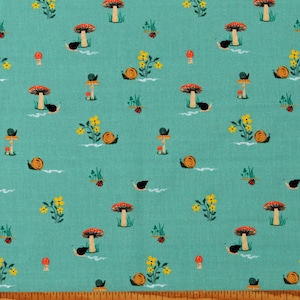 May include: Teal fabric with a repeating pattern of red and white mushrooms, yellow flowers, and black snails. The fabric is shown with a ruler for scale.