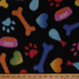 May include: Black fabric with a repeating pattern of colorful dog-themed elements. The design includes paw prints, bones, hearts, and dog food bowls with the word "DOG" on them. The colors are bright and varied, including blue, orange, red, and yellow.