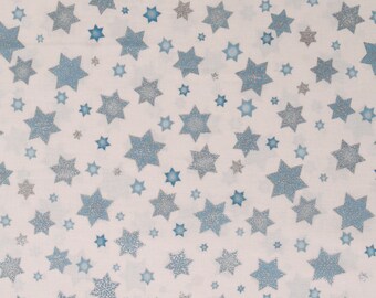 May include: White fabric with a repeating pattern of blue and silver glitter stars.