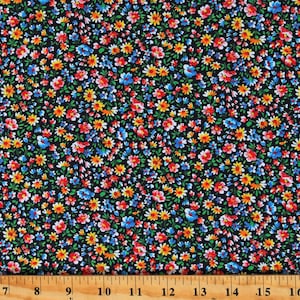 May include: Black fabric with a small floral print in shades of red, blue, yellow, and white. The fabric is shown with a ruler for scale.