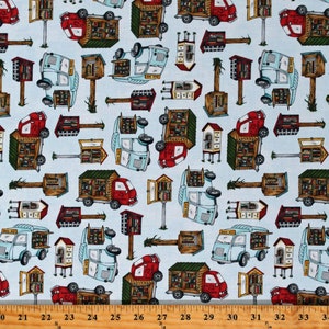 May include: A blue and white patterned fabric with a repeating design of red and blue bookmobile trucks and wooden book exchange boxes. The fabric has a ruler with inches marked along the bottom.