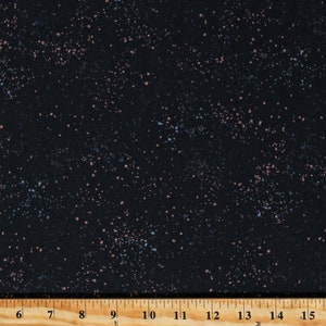 May include: Black fabric with a speckled pattern of small blue and pink dots. The fabric is measured with a ruler in inches.