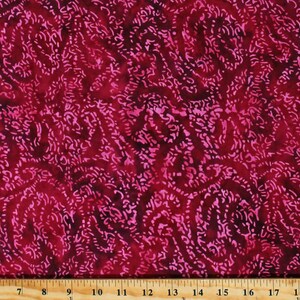 May include: Red fabric with a pink paisley pattern. The fabric is measured with a ruler in inches.