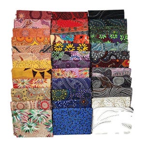 May include: A stack of 24 fabric squares featuring various Aboriginal Australian art designs. The squares are in a variety of colors, including black, white, red, yellow, blue, and green. The designs are intricate and colorful, and they are all different.