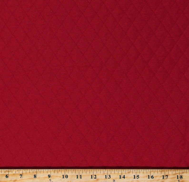 May include: Red fabric with a diamond pattern. The fabric is textured and has a subtle sheen.