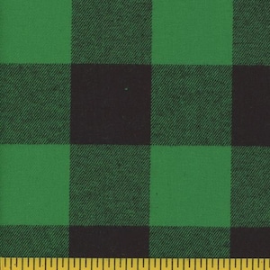 May include: Green and black buffalo plaid fabric. The fabric features large, evenly spaced squares in a classic plaid pattern. A yellow measuring tape is at the bottom of the image, showing inches.