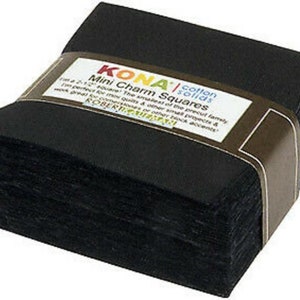 May include: A stack of black Kona cotton mini charm squares, each 2.5 inches square, wrapped with a brown label. The label features the text "KONA Mini Charm Squares" and "cotton solids".