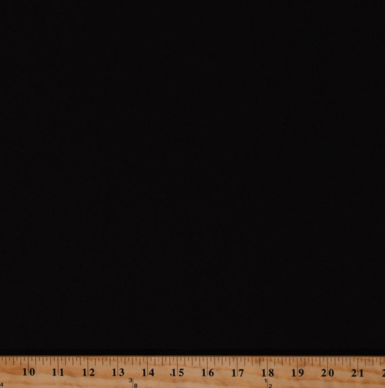 May include: A solid black fabric with a measuring tape along the bottom edge. The tape is marked with inch increments, starting at 10 and extending to 21. The fabric appears to be smooth and opaque.