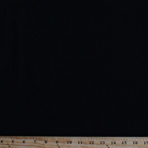 May include: A black fabric swatch with a wooden ruler measuring 17 inches.