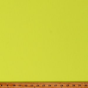 May include: A bright yellow fabric swatch with a wood ruler measuring 22 inches.