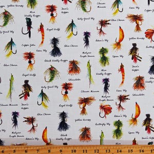 May include: A white fabric with a repeating pattern of colorful fishing flies. Each fly is labeled with its name, such as "Holy Grail Fly", "Dave's Hopper", and "Black Woolly Bugger".