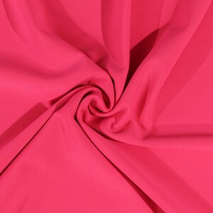 May include: A close-up of a bright pink fabric, showing its smooth texture and soft drape.