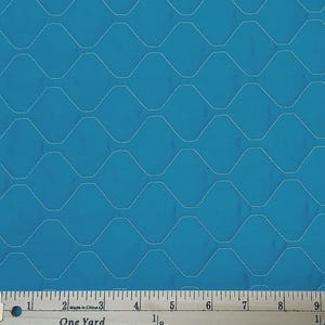 May include: Teal fabric with a repeating geometric pattern of white stitched lines. The fabric has a ruler along the bottom edge with the text "One Yard".