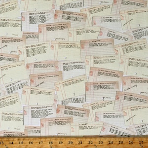 May include: A close-up of a fabric with a repeating pattern of vintage-style library cards. The cards have a cream background with black text and lines. The text on the cards includes book titles, author names, and publication dates. Some of the cards have handwritten notes on them, such as "smells musty" and "how old".
