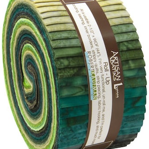 May include: A roll of Artisan Batiks fabric in shades of green, from light to dark, with a brown label wrapped around it. The label reads "Roll-Up" and includes text about the fabric's uses, such as strip piecing and sashing.