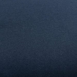 May include: A close-up shot of a navy blue fabric. The texture appears soft and slightly fuzzy, with subtle variations in tone across the surface. The color is a deep, solid navy, with no visible patterns or designs.