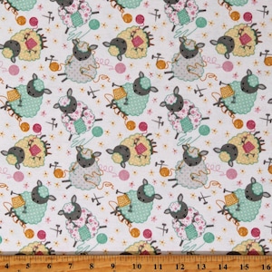 May include: White fabric with a repeating pattern of gray sheep knitting yarn balls. The sheep are wearing pink, green, and yellow clothing.