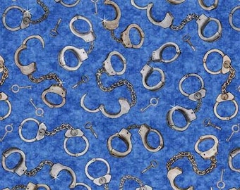 Peut inclure: Un tissu bleu avec un motif répété de menottes et de clés argentées. Les menottes sont reliées entre elles par une chaîne.