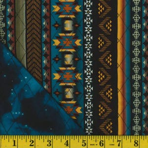 May include: A close-up of a teal blue fabric with a repeating pattern of geometric shapes in shades of brown, yellow, white, and red. The fabric is quilted and has a subtle sheen.