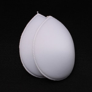 May include: Two white foam bra inserts with a scalloped edge.
