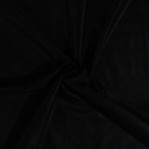 May include: Black fabric with a smooth, silky texture. The fabric is folded and draped, creating soft folds and curves.