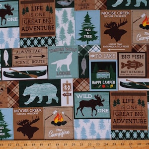 May include: A green and brown fabric with a repeating pattern of woodland scenes. The fabric features images of moose, bears, wolves, fish, and a camper. The fabric also includes text such as "Life is one great big adventure", "Timber Wolf", "Moose Creek Nature Preserve", and "The Campfire".