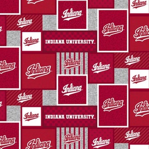 May include: A red and white fabric pattern with the repeated text "Indiana University" and the word "Indiana" in a stylized font.
