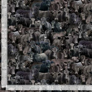 May include: A fabric pattern featuring a dense arrangement of black cows. The cows are in various poses, creating a textured, monochromatic design. The image has a scale in inches on the left side.