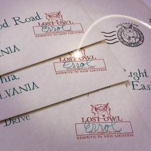 May include: Off-white envelopes featuring a red stamp with an owl graphic, the text LOST OWL, Errol, Owl assigned to route, and REROUTE TO NEW LOCATION. One envelope displays a black HOGSMEADE OWL POST circular stamp with an owl holding a letter.