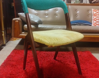 May include: A vintage wooden chair with a teal green back and a yellow seat cushion. The chair is on a red shag carpet.