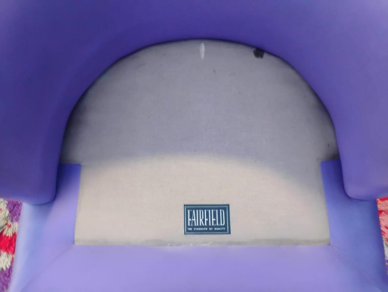 May include: Purple fabric chair with a white fabric seat. The seat has a label that reads "Fairfield, The Standard of Quality".