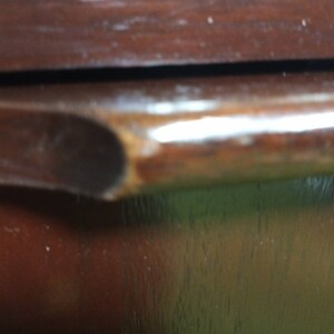 Pu&ograve; includere: Primo piano di una porta di armadio in legno marrone scuro con una maniglia in legno marrone scuro liscia.