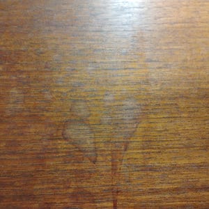 May include: A close-up of a wood grain surface with a light brown color. The surface has a natural wood grain pattern and a smooth texture.