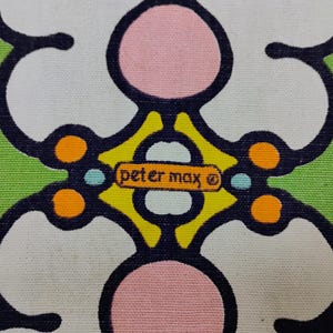 May include: Close-up of a fabric with a repeating floral pattern in white, pink, and black on a green background. The design includes the text "peter max" in a small rectangular box.