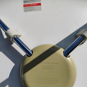 K&ouml;nnte beinhalten: Unterseite eines hellgr&uuml;nen Stuhlsitzes mit Chrombeinen. Der Stuhl ist mit "REPUBLIC OF Fritz Hansen" und "DESIGN ARNE JACOBSEN" gekennzeichnet. Der Stuhl wird in D&auml;nemark hergestellt.
