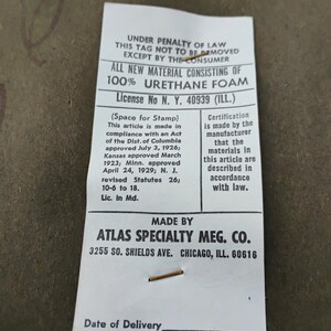 Puede incluir: Una etiqueta de producto rectangular blanca con texto negro que dice: UNDER PENALTY OF LAW THIS TAG NOT TO BE REMOVED EXCEPT BY THE CONSUMER. ALL NEW MATERIAL CONSISTING OF 100% URETHANE FOAM. MADE BY ATLAS SPECIALTY MFG. CO. 3255 SO. SHIELDS AVE. CHICAGO, ILL. 60616.