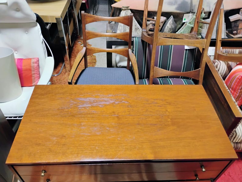 Puede incluir: Una c&oacute;moda de madera con dos cajones y un acabado marr&oacute;n claro. La c&oacute;moda tiene un aspecto ligeramente desgastado con algunos ara&ntilde;azos ligeros en la superficie.
