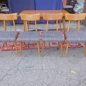 May include: Set of four mid-century modern dining chairs with wooden legs and striped fabric seats.