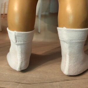 May include: A pair of white ankle socks with a seam down the back of each sock.