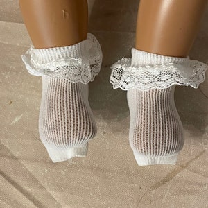 May include: A pair of white lace ankle socks with a ruffled trim. The socks are made of a soft, breathable fabric and are perfect for everyday wear.