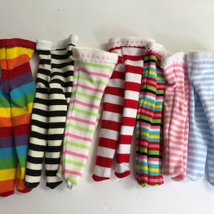 May include: Seven pairs of striped leggings in various colors, including rainbow, black and white, pink and green, red and white, green and yellow, pink and white, and blue and white.