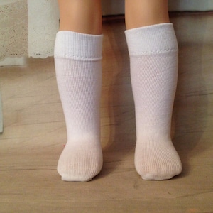May include: A pair of white knee-high socks with a ribbed texture.