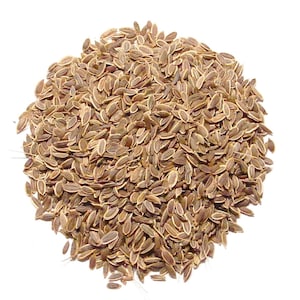 May include: A close-up image of a pile of dill seeds. The seeds are small, oval-shaped, and light brown in color. They are densely packed together against a white background, creating a textured appearance. The seeds are commonly used in cooking and for their aromatic properties.