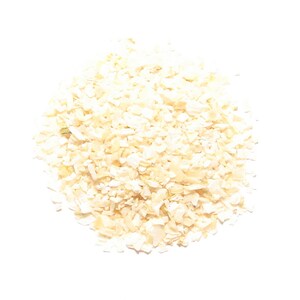 May include: A pile of dehydrated, chopped onion flakes, light beige in color, against a white background. The flakes are irregularly shaped and appear dry, suitable for culinary use.